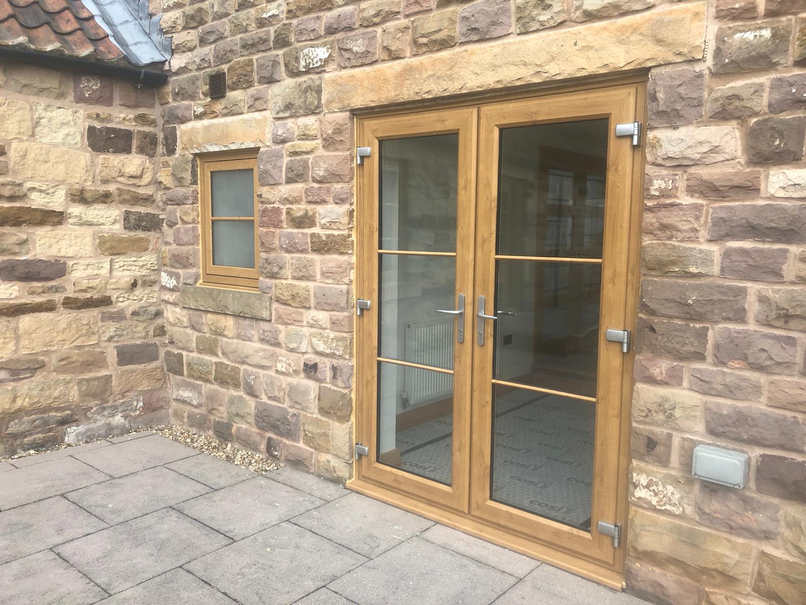 bare stone and timber uPVC doors