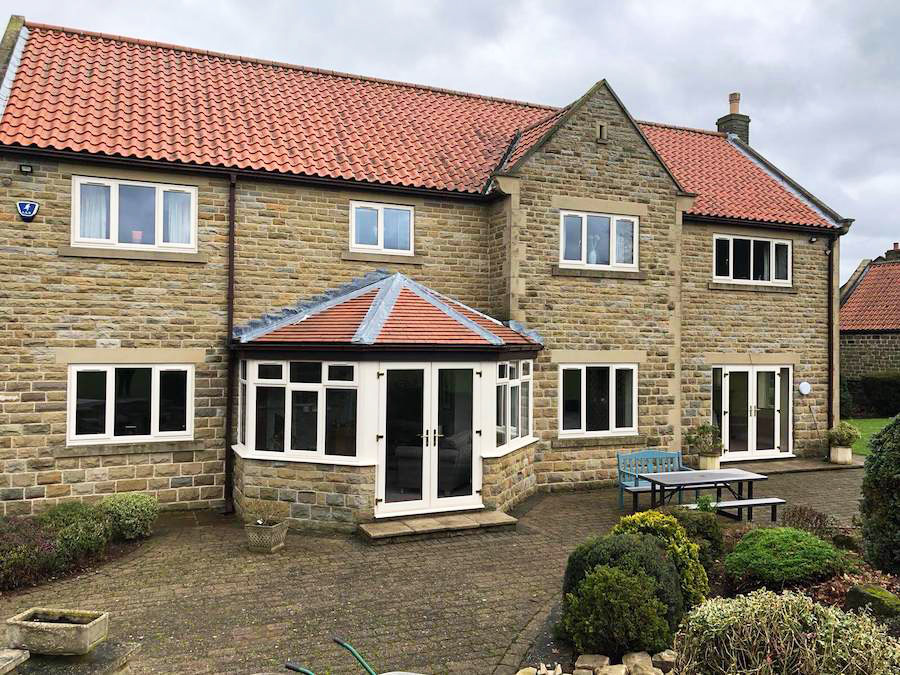 Full Window replacement with white uPVC casement windows and a french door on a country house.